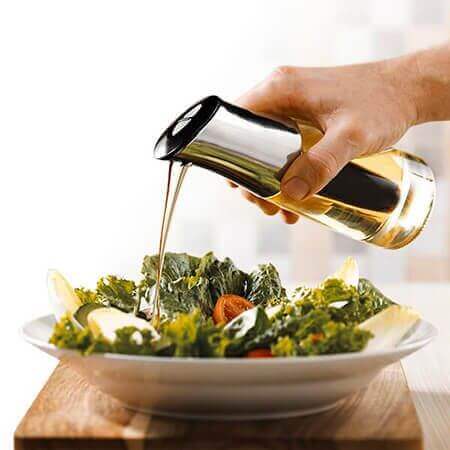 Shopping online utensílios de cozinha com azeite sendo derramado em salada fresca verde em prato branco