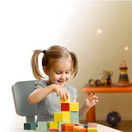 Menina pequena brincando com blocos coloridos em brinquedos educativos para crianças