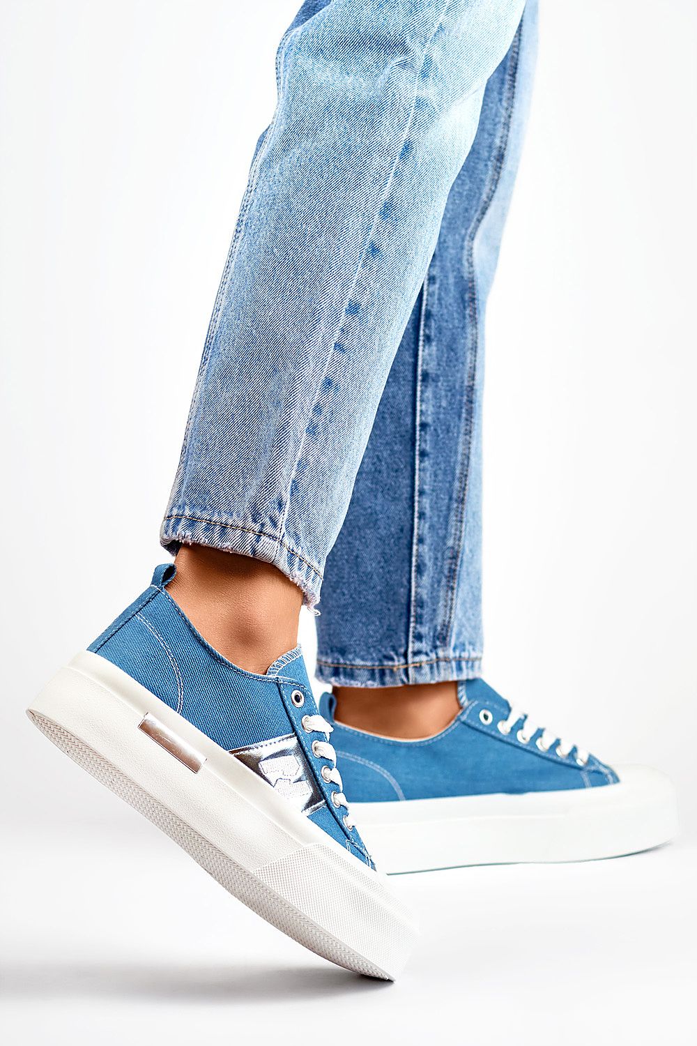 Tênis casual feminino azul da PRIMO com solado branco usados com jeans