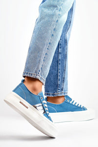 Tênis casual feminino azul da PRIMO com solado branco usados com jeans